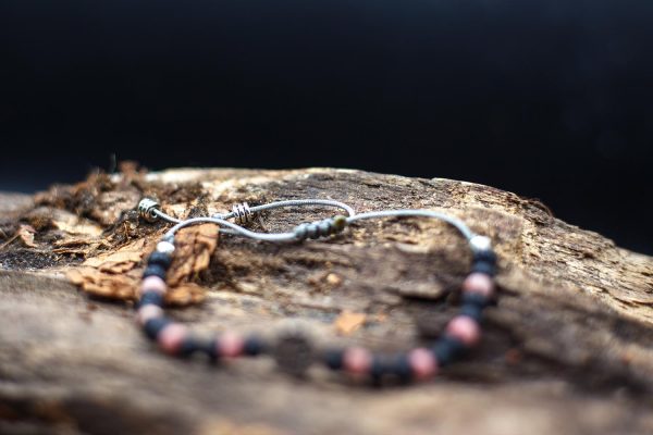Rózsaszín rodonit és lávakőből készült karkötő csúszó csomós megoldással, fém köztessel, szürke madzagon