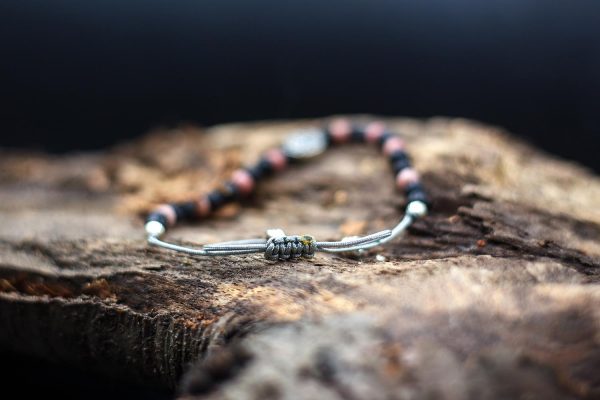 Rózsaszín rodonit és lávakőből készült karkötő csúszó csomós megoldással, fém köztessel, szürke madzagon