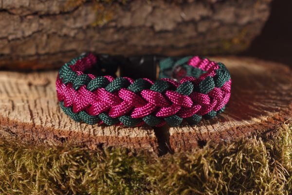 Magenta és sötétzöld paracord kötélből készült karkötő fekete műanyag csattal.